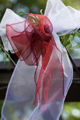 Red and white wedding ribbons hanging from a gazebo