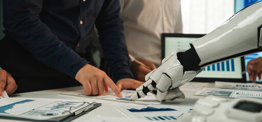 A dynamic scene showcasing a human-robot collaboration in a modern office, focusing on financial analysis with detailed reports, charts, and technology integration.Noogenesis