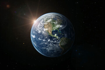 Obraz premium Planet Earth glowing in the vastness of space with sun rays and stars galaxy