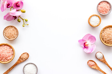 Fototapeta na wymiar Beauty spa therapy cosmetics and wellness flat lay - sea salt in many bowls with flowers, top view