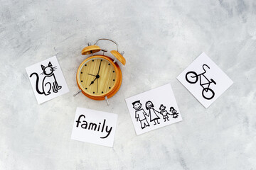 Retro alarm clock and many paper cards with hand drawing of different life activities, top view....