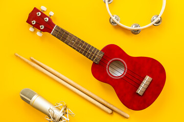 Musical instruments for band - small guitar, drumsticks and tambourine with studio microphone....