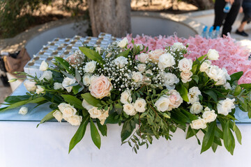Delicate floral arrangement on display at a sunny outdoor celebration in a scenic park setting