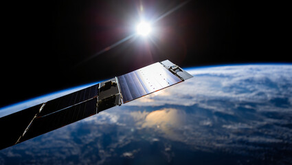 A closeup view of a satellites solar panel in orbit above the earth