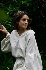 Portrait of a young attractive woman with a headscarf looking thoughtfully to the side, posing...