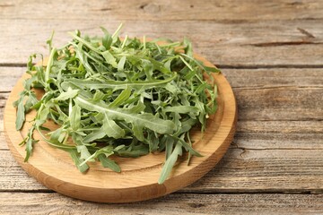 Fresh ripe green arugula leaves on wooden table, closeup