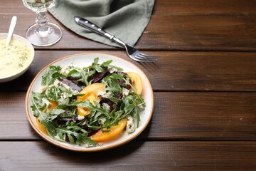 Tasty salad with arugula, blue cheese and vegetables on wooden table. Space for text