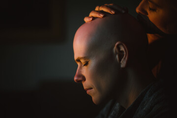 Man gently resting his partners hand on his head in a warm, intimate moment during evening relaxation at home