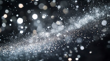 Abstract silver glitter and bokeh lights on black background.