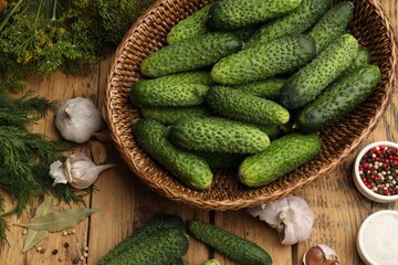 Making pickles. Fresh cucumbers and other ingredients on wooden table, flat lay