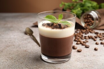 Delicious coffee panna cotta, beans and mint on grey table, closeup