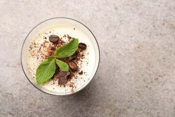 Delicious coffee panna cotta with beans and mint on grey table, top view. Space for text