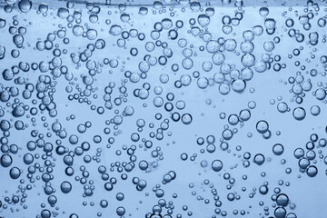 Soda water with bubbles of gas in glass, closeup