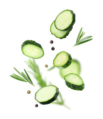 Cucumber slices, rosemary and peppercorns falling against white background