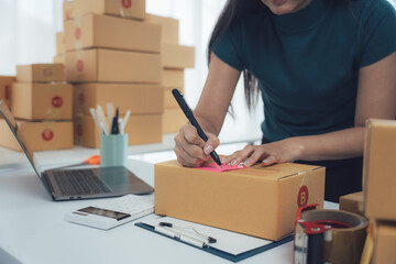 E-commerce Preparation: An entrepreneur meticulously prepares packages for shipment in a modern...