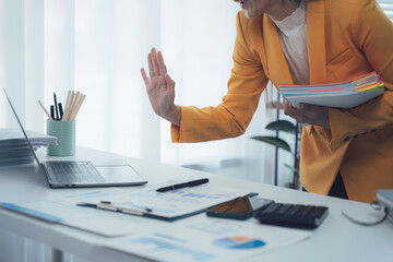 Businesswoman's Halt Gesture: A professional woman makes a decisive gesture, bringing a halt to a...