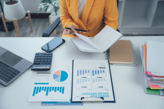 Focused Analysis: A top-down perspective of a focused individual in a professional setting, engrossed in detailed financial reports and data analysis, the essence of business