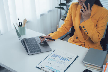 Businesswoman at Work: An elegant businesswoman, diligently multi-tasking in a professional...