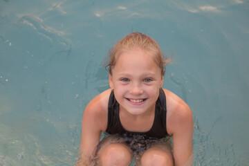 Happy Girl in Swimming Pool Smiling at Camera