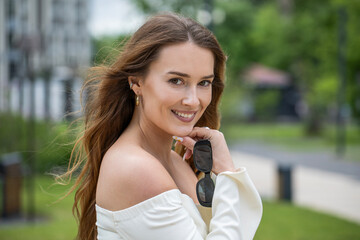 Young beautiful model in a white short dress with long sleeves