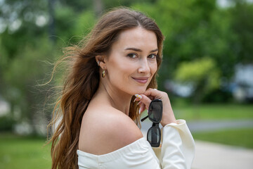 Young beautiful model in a white short dress with long sleeves