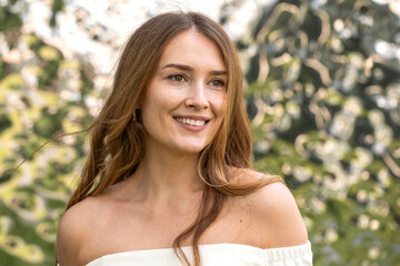 Young beautiful model in a white short dress with long sleeves