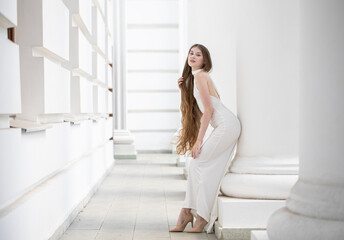 Fototapeta premium Fashion portrait of a young beautiful blonde woman in a long white gown