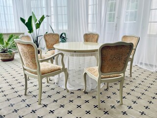 Luxurious castle room arranged for intimate gatherings, with four antique chairs around a central...