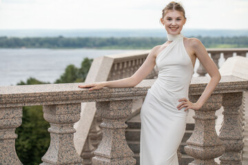 Young beautiful woman in a long white dress
