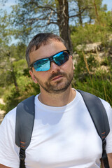 Man wearing sunglasses and backpack outdoors in nature