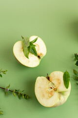 Green apples and fresh herbs on a minimalist background