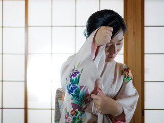 顔を隠す着物の女性