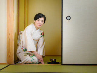 お茶をお出しする着物の女性