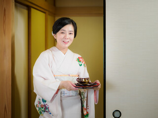 お茶をお出しする着物の女性