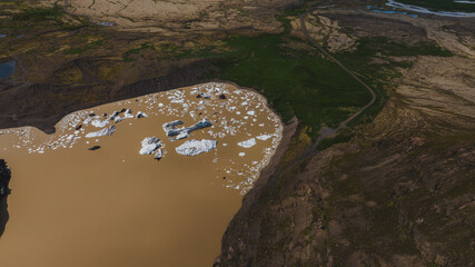 Aerial View of Glacial Lagoon with Icebergs and Rugged Terrain in Iceland