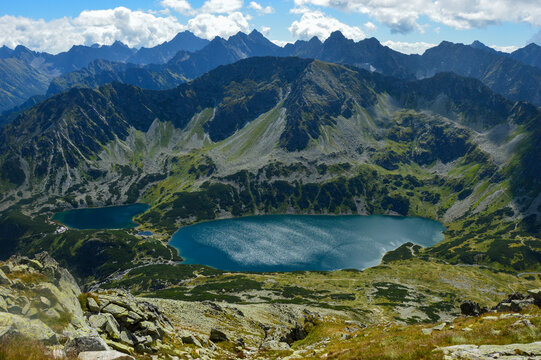 Alpine lakes in green mountain valley from summit view