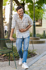 Arabian young man traveler feeling sudden strong abdominal stomach ache, gastritis problem. Upset...