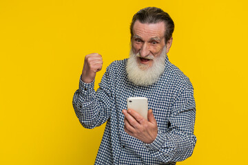 Happy excited senior elderly old man grandfather use smartphone typing browsing shouting say wow...