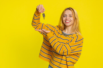 Caucasian young blonde woman real estate agent lifting hand showing the keys of new home house...