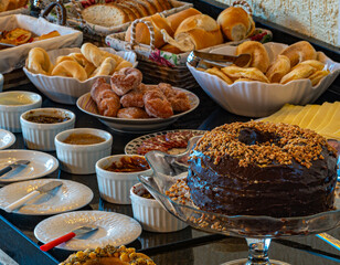 
Hearty breakfast served with cakes, pies, jams, pastries, cheese, ham, coffee, milk, cheese bread...