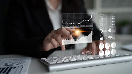 A business professional engages with digital financial charts and graphs on a laptop, demonstrating modern data analysis and strategic decision-making in a professional environment. Impute