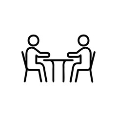 Two people sitting at a table discussing business or ideas