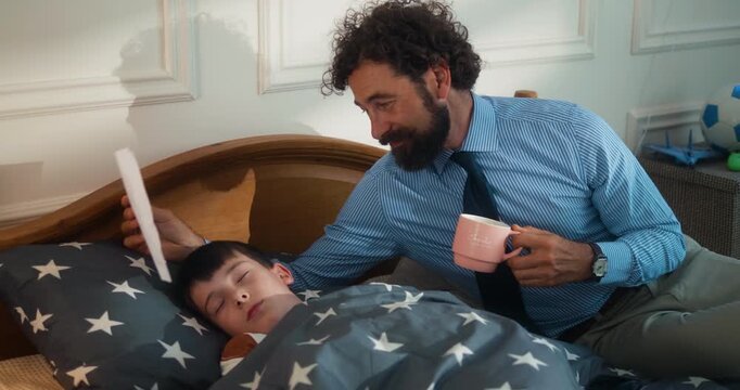 Emotional busy business father looking with emotion at his son's drawing while he sleeps, too busy at work focusing on careers, children eager parents