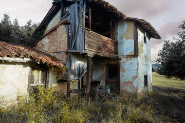Abandoned rural house in Asturias, Spain, with weathered walls, exposed bricks, broken wooden...
