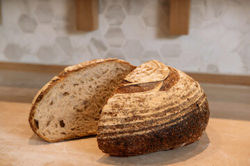 Pain Au Levain Dark Sourdough Bread with sliced half Isolated on wooden Background closeup side view of italian baked