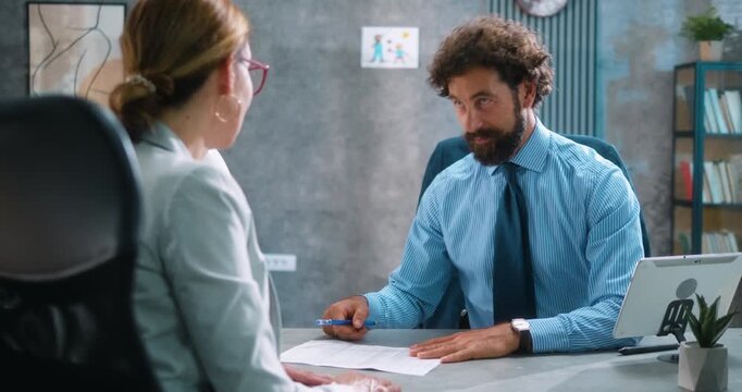 Bank employee manager successfully finalizes a loan agreement with a female client, ending the professional consultation with a friendly handshake. Part 22 of the “Dad’s Day” series.