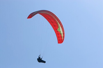 Paraglider flying in a blue sky	