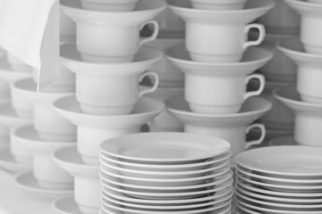 Stacked White Crockery and Teacups Neatly Arranged for Catering Service