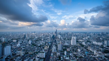 Obraz premium A vast cityscape reveals tall buildings and busy streets as twilight approaches. The dramatic clouds above hint at an impending evening, showcasing urban life below.