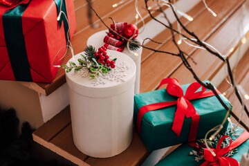 Colorful holiday gifts arranged on wooden stairs with festive decorations in a cozy setting